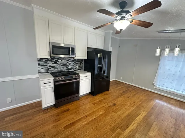 a kitchen with stainless steel appliances a stove a refrigerator and a microwave