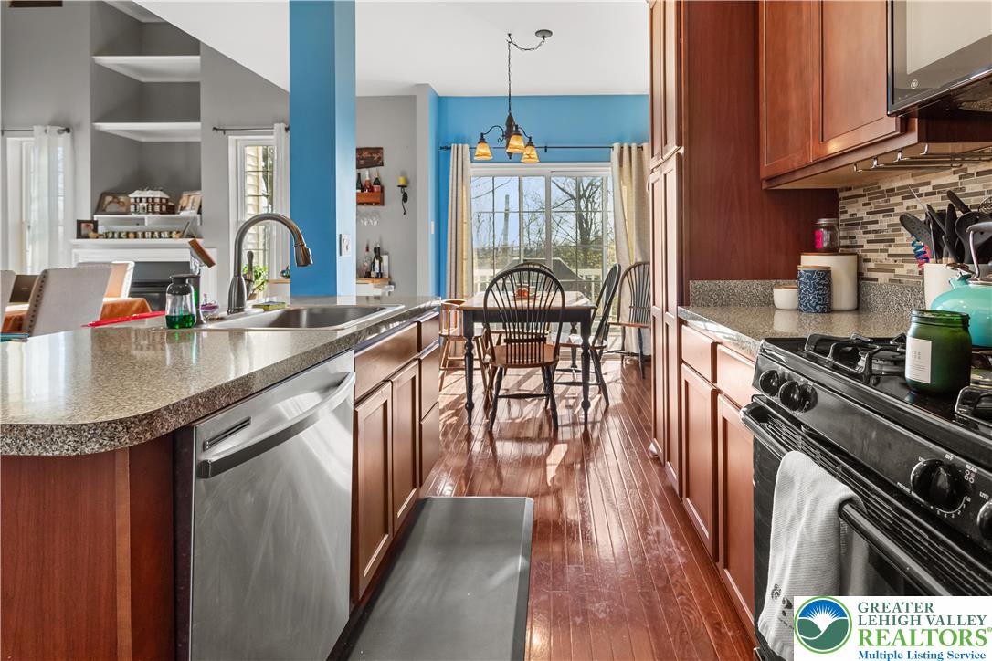 3420 Westminster Way Nazareth, PA 18064 - Photo 6 of 21 a kitchen with granite countertop a stove a sink dishwasher and cabinets with wooden floor