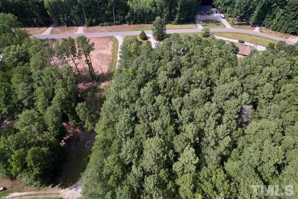 an aerial view of residential house with outdoor space and trees all around