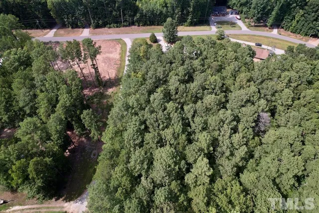 an aerial view of residential house with outdoor space and trees all around