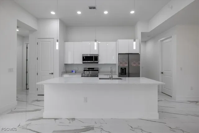 a kitchen with stainless steel appliances a refrigerator sink and microwave