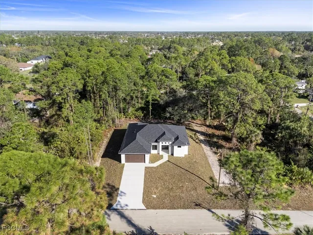 an aerial view of residential house with outdoor space and trees all around