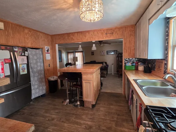 a kitchen with refrigerator and chairs