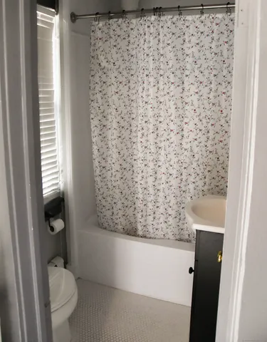 a bathroom with a toilet and a shower curtain