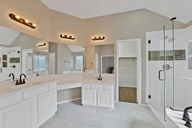 a bathroom with a double vanity sink mirror and shower