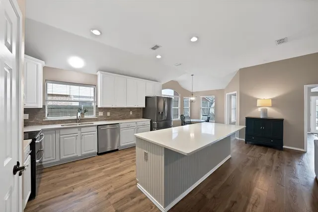 a large kitchen with kitchen island a sink and a stove top oven