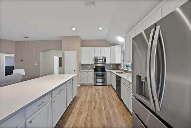 a large kitchen with a large window and stainless steel appliances
