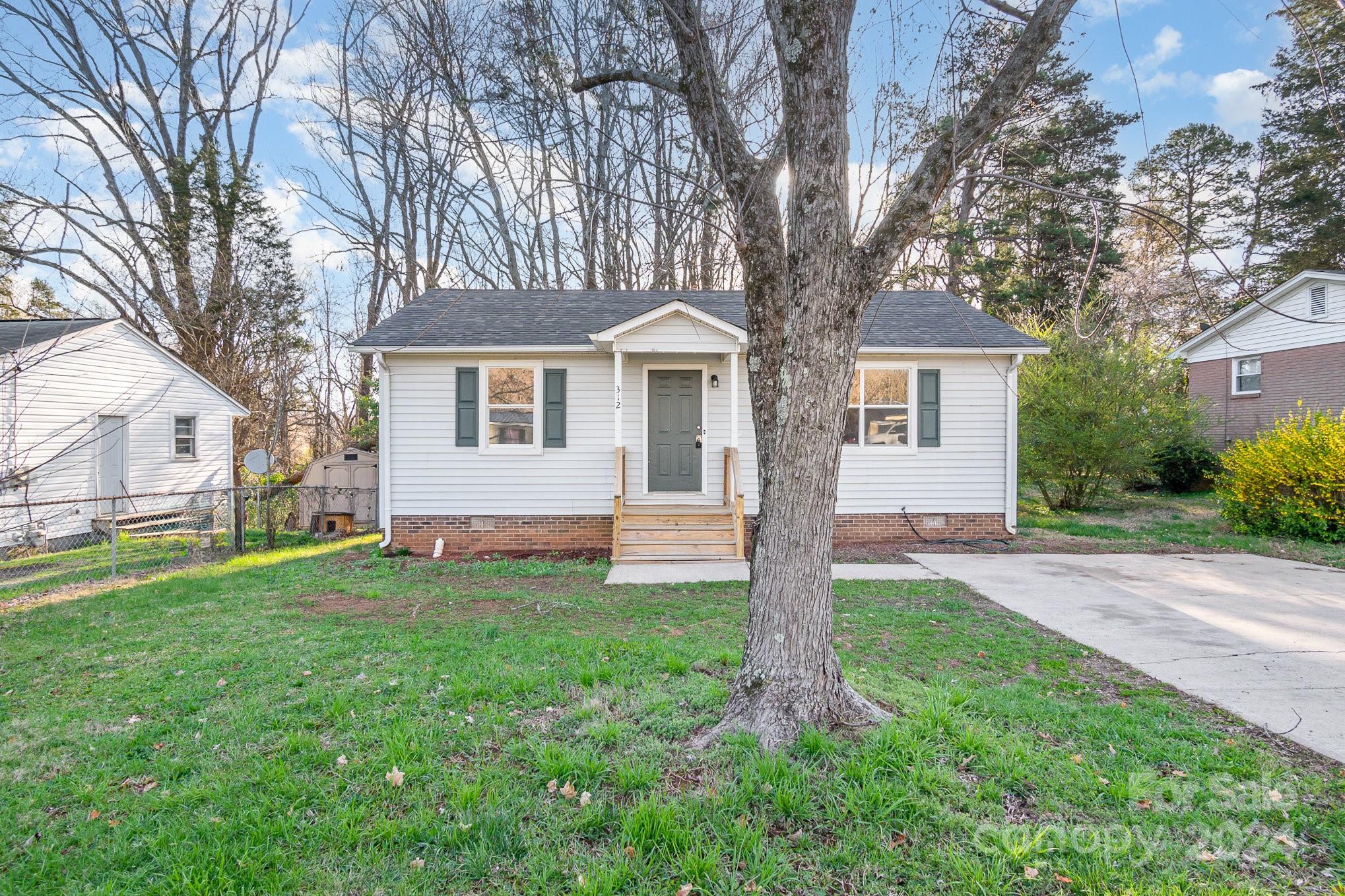 a house that has a tree in front of a house