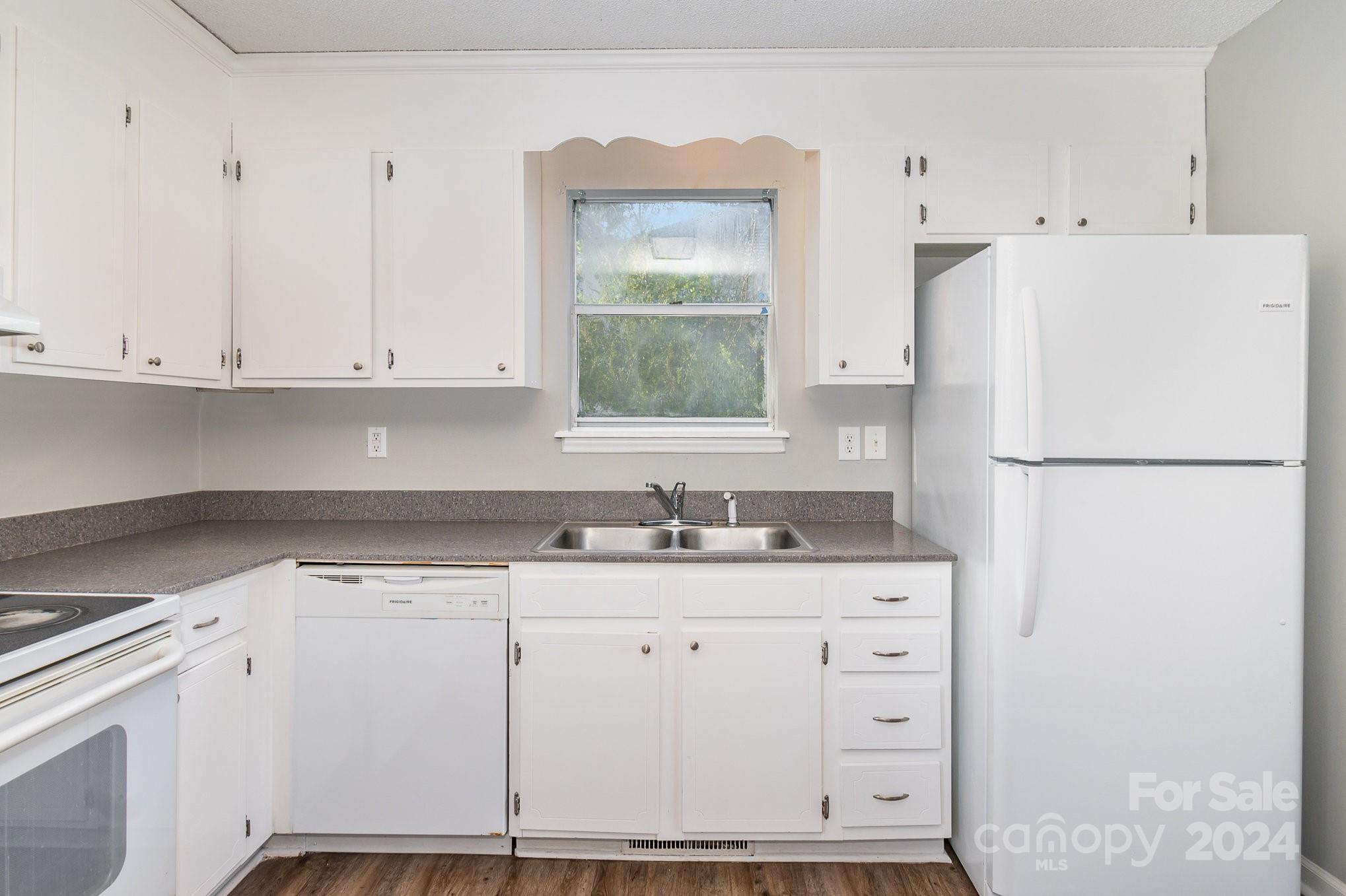 312 Moore Drive Lexington, NC 27292 - Photo 11 of 19 a kitchen with granite countertop white cabinets and white appliances