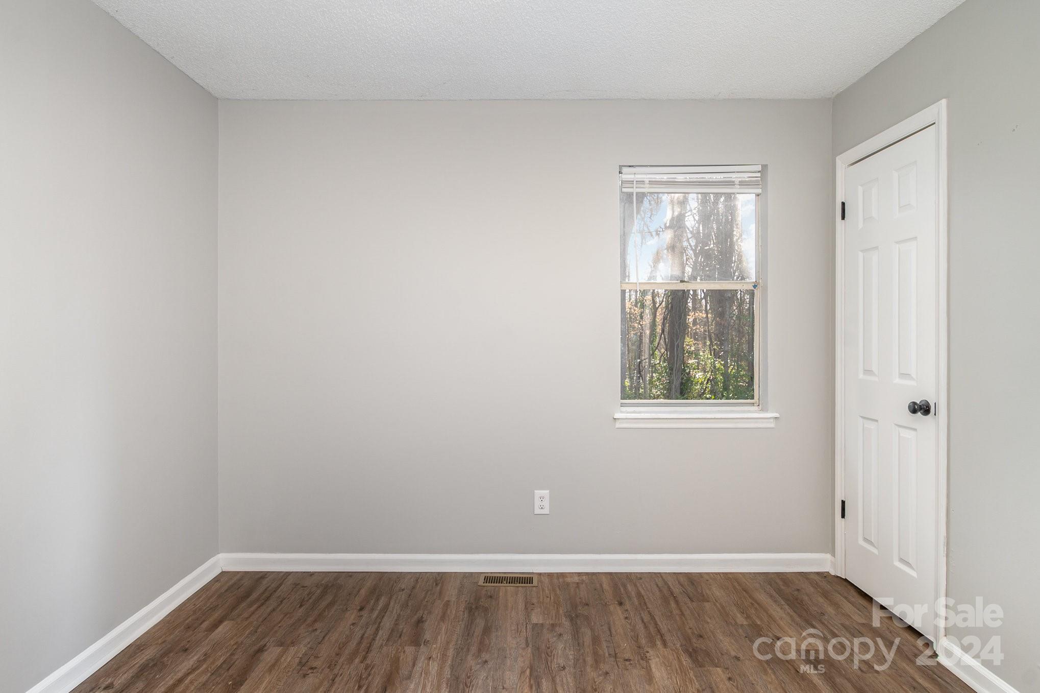 312 Moore Drive Lexington, NC 27292 - Photo 14 of 19 a view of an empty room with wooden floor and a window