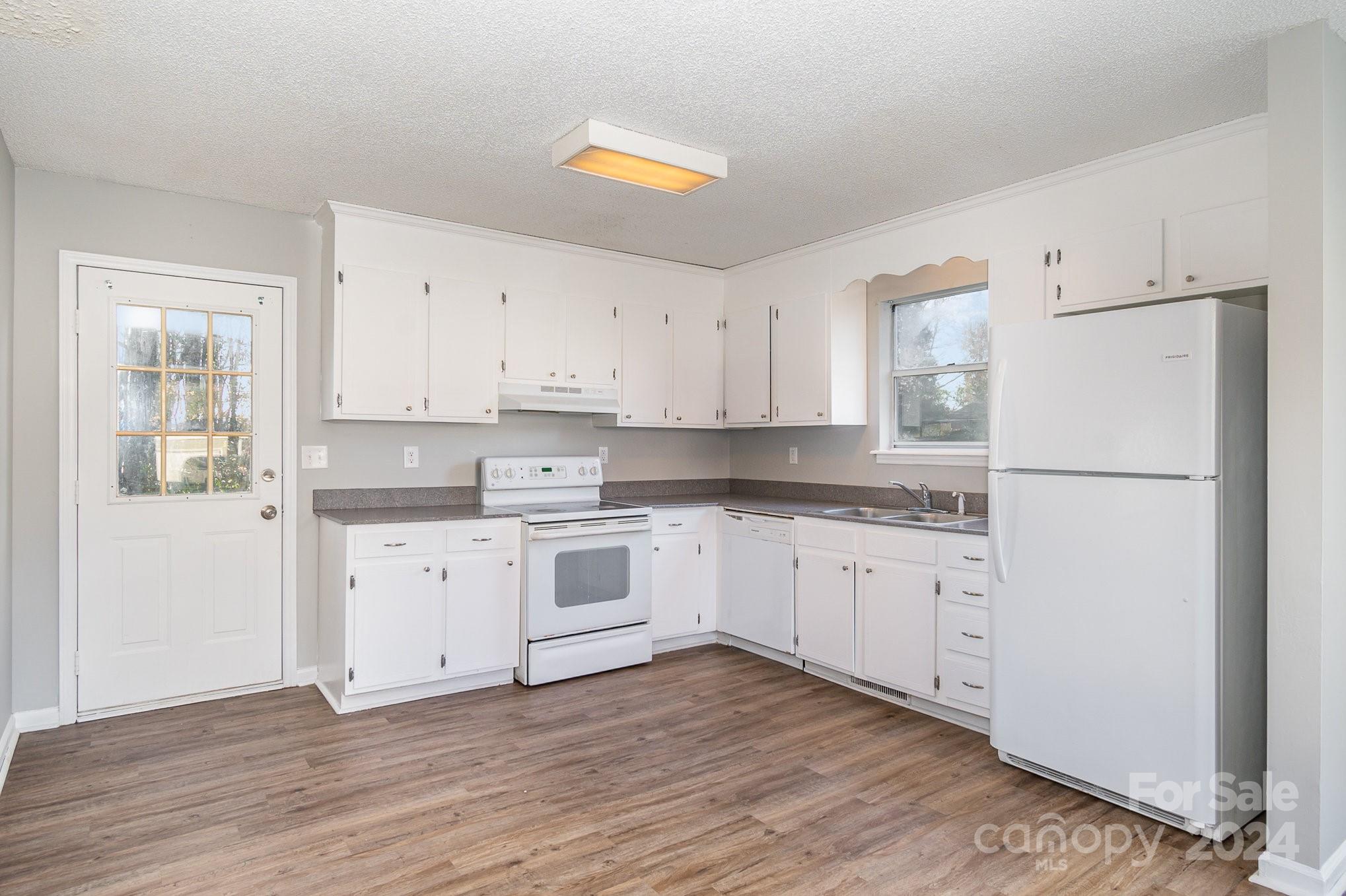 312 Moore Drive Lexington, NC 27292 - Photo 3 of 19 a kitchen with granite countertop white cabinets and white appliances