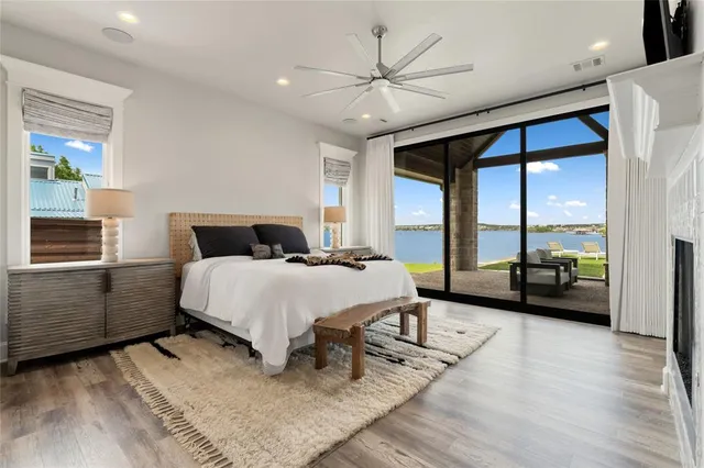 a bedroom with a bed a large window and wooden floor