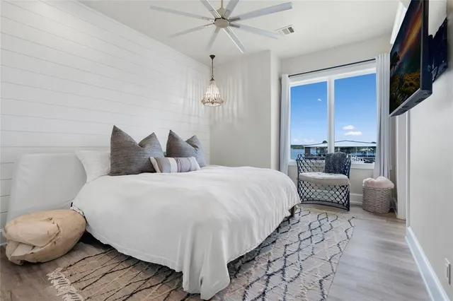 a bedroom with a bed a couch and chandelier