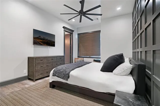 a bedroom with a bed a window and a flat screen tv