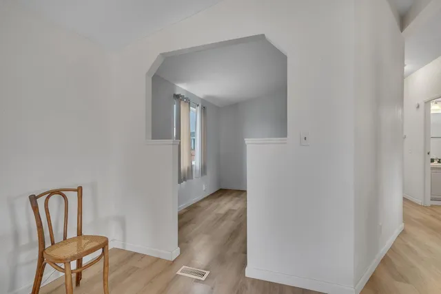 a view of a hallway with wooden floor and chair