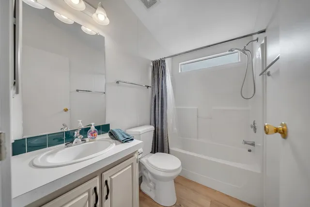 a bathroom with a sink vanity granite toilet and shower