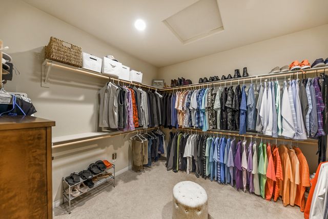 a view of walk in closet with clothes and shoes