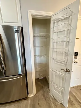 a view of a hallway with wooden floor and closet area
