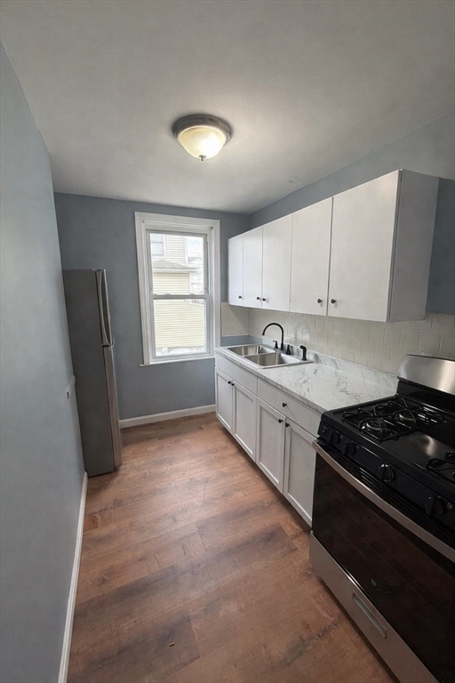 50 Haffards Street, Unit 1 Fall River, MA 02723 - Photo 2 of 8 a kitchen with stainless steel appliances granite countertop a stove a sink and a refrigerator
