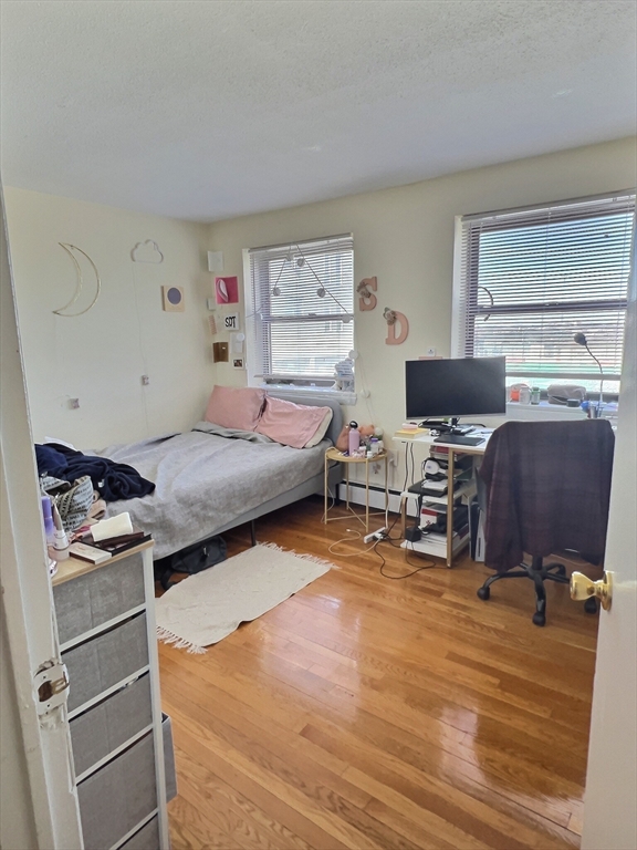 1039 Commonwealth Avenue, Unit 18 Boston, MA 02215 - Photo 4 of 6 a bedroom with furniture and a wooden floor