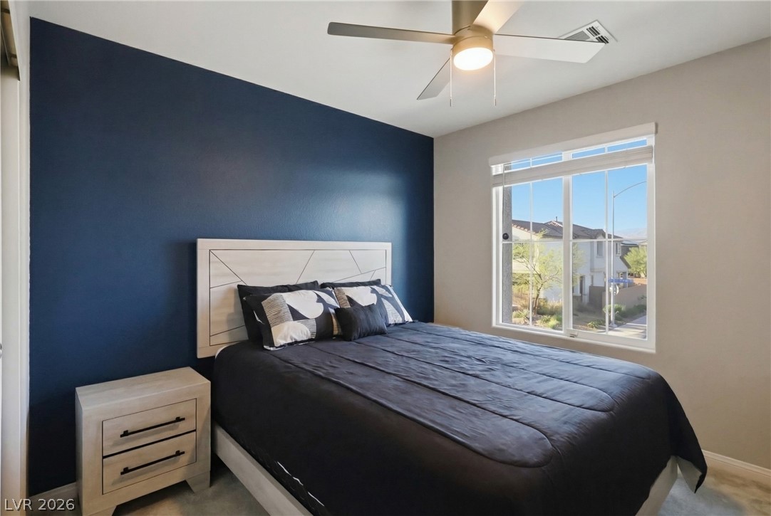 1921 Miller Ridge Avenue North Las Vegas, NV 89031 - Photo 13 of 26 This cozy bedroom features a stylish ceiling fan and ample natural light through a large window.