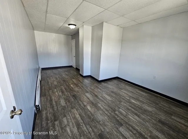 a view of a room with wooden floor and white walls