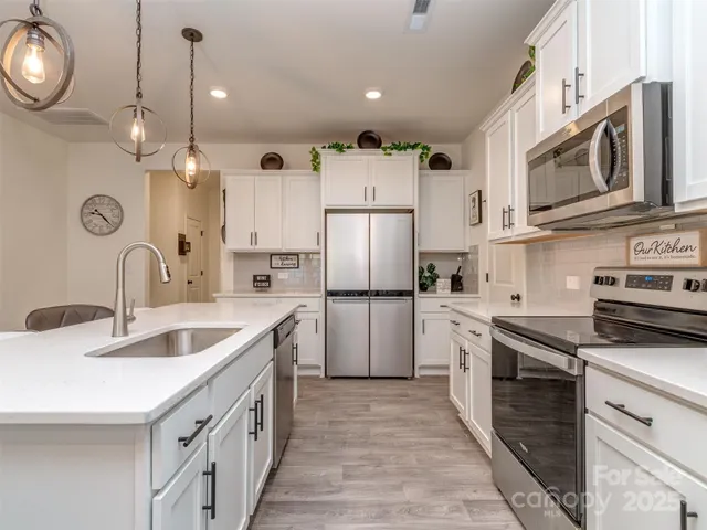 a kitchen with white cabinets and stainless steel appliances