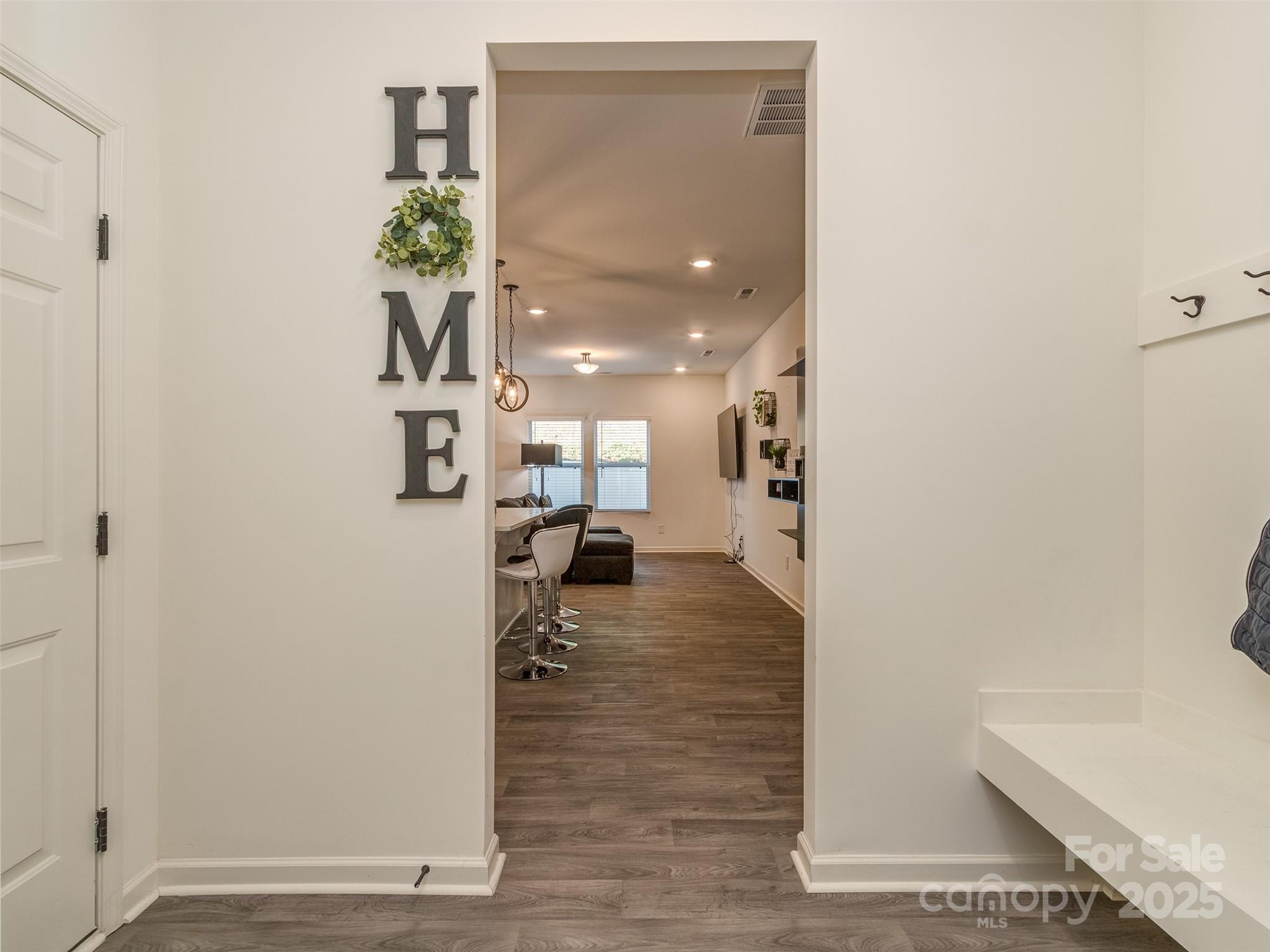 2024 Crooked Oak Lane York, SC 29745 - Photo 5 of 25 a view of a hallway with wooden floor and a living room