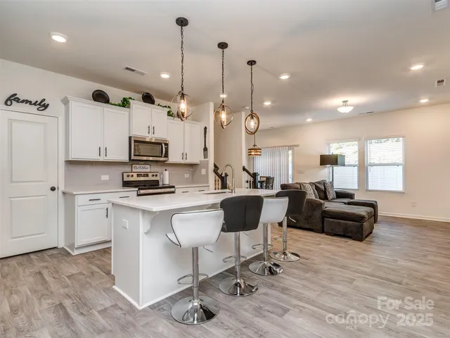 a view of kitchen with microwave stove top oven and cabinets