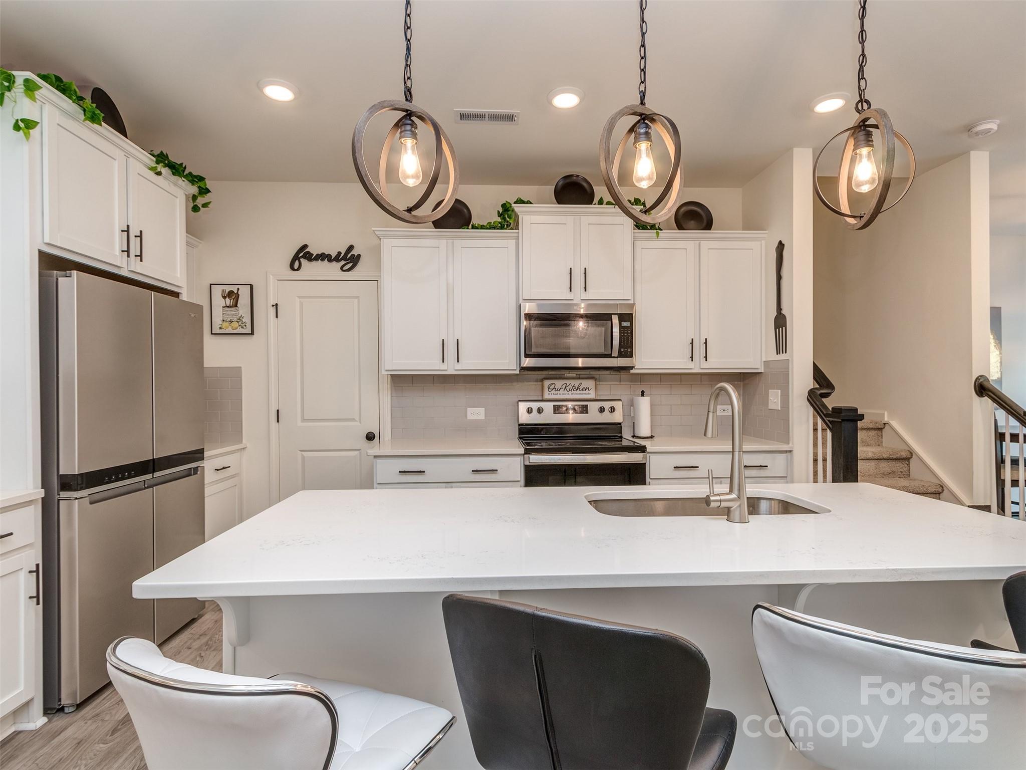2024 Crooked Oak Lane York, SC 29745 - Photo 9 of 25 a kitchen with stainless steel appliances a table chairs refrigerator and microwave