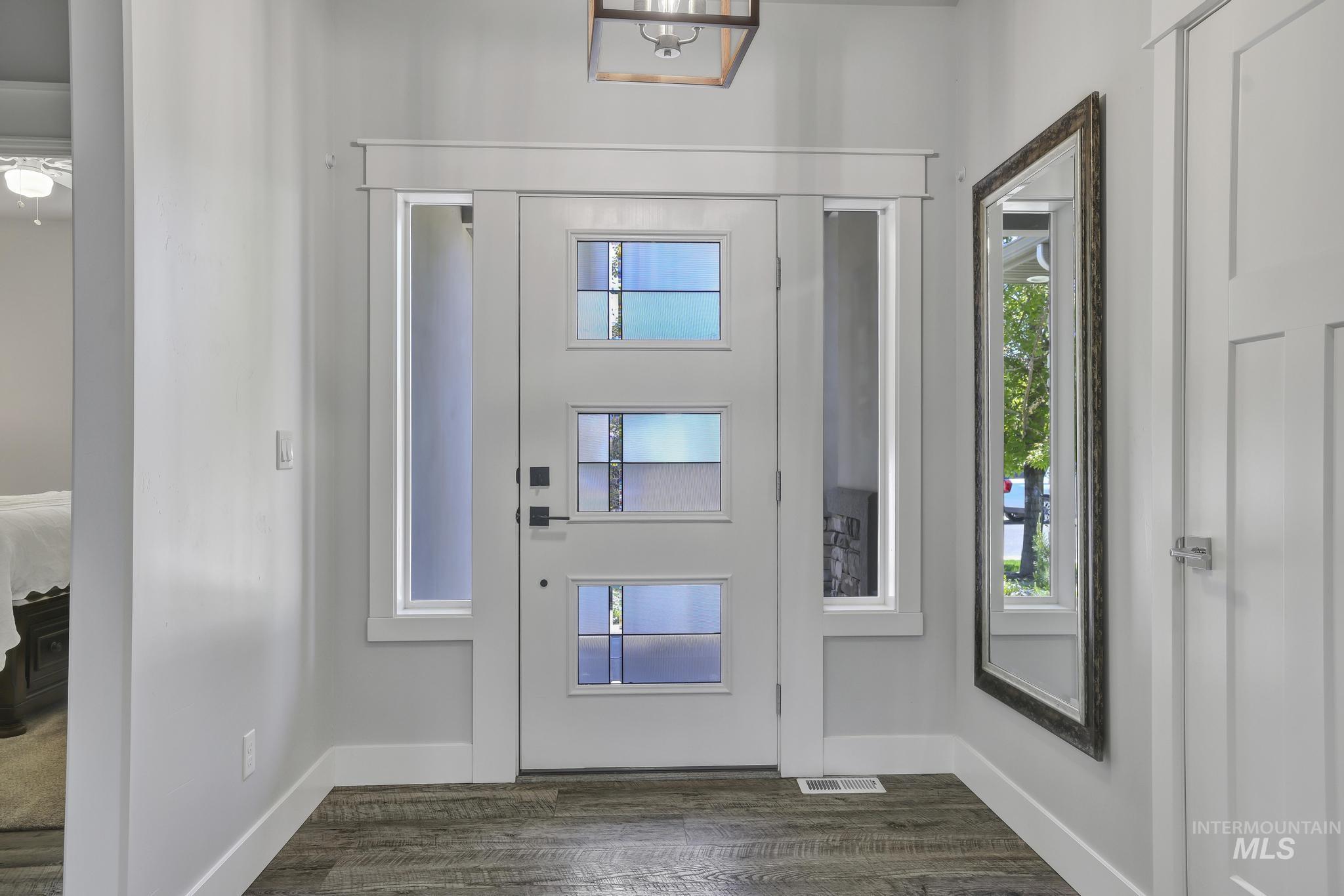 1937 Tamarack Loop Twin Falls, ID 83301 - Photo 7 of 50 Entryway featuring a white door with three decorative glass inserts, sidelight windows, and wood-finish flooring