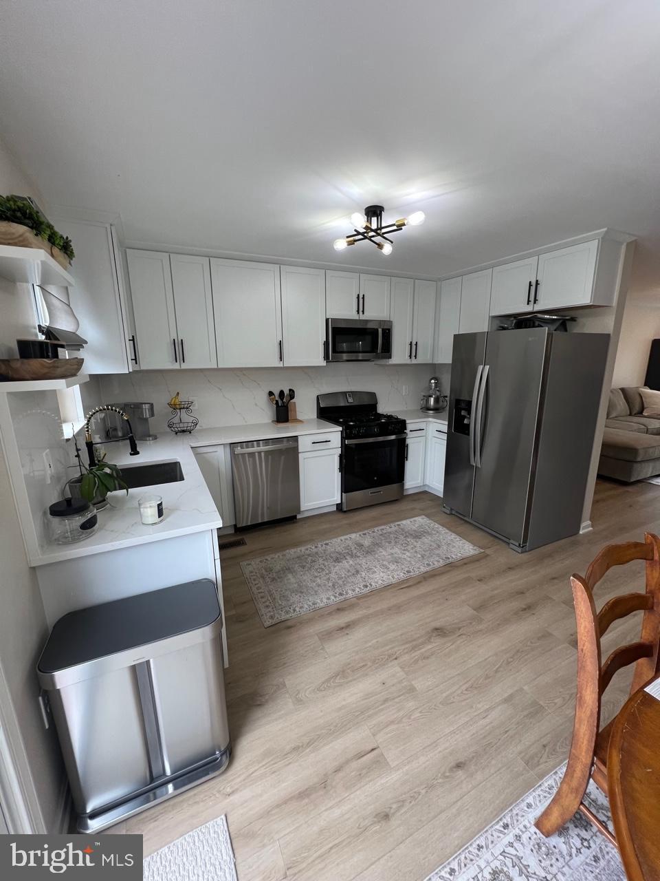 20202 Foothill Terrace Ashburn, VA 20147 - Photo 8 of 26 a kitchen with kitchen island white cabinets and refrigerator