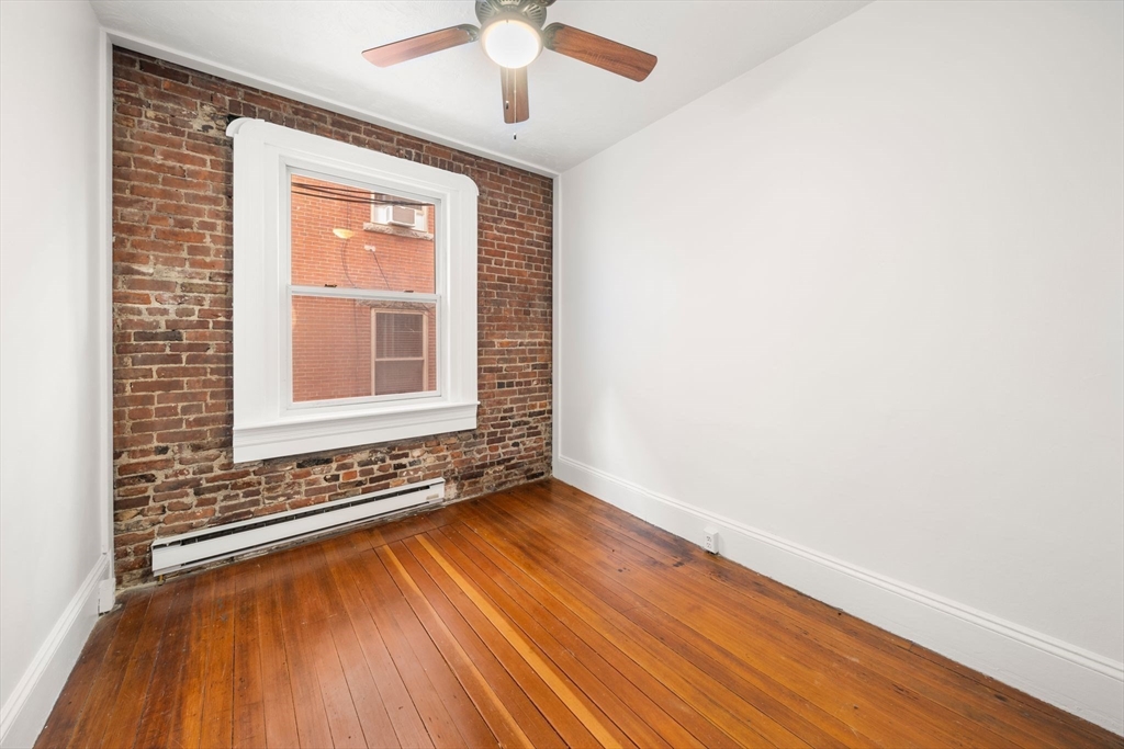 7 Unity Street, Unit 3 Boston, MA 02113 - Photo 17 of 25 an empty room with wooden floor chandelier and windows