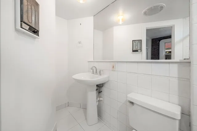 a bathroom with a sink a toilet and mirror