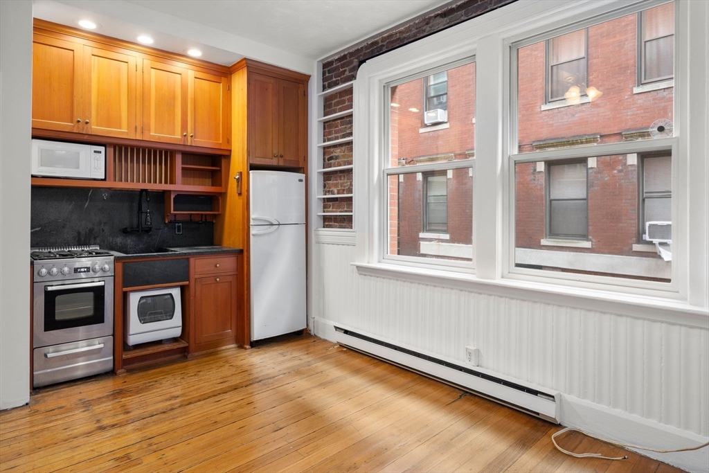 7 Unity Street, Unit 3 Boston, MA 02113 - Photo 4 of 25 a view of a kitchen with an empty room and wooden floor