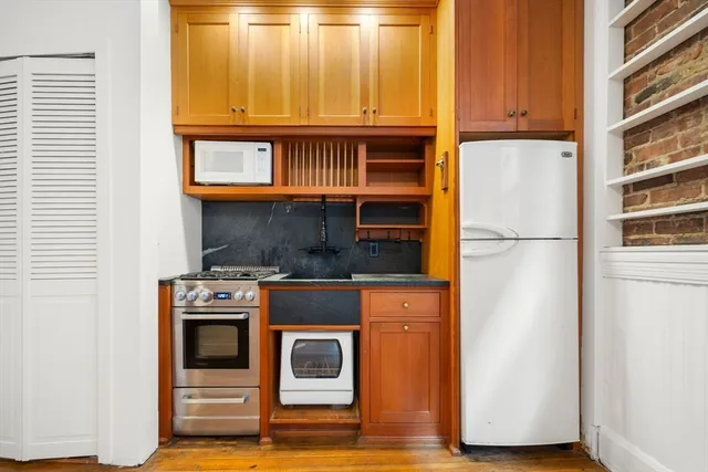 a kitchen with stainless steel appliances granite countertop a refrigerator and a stove