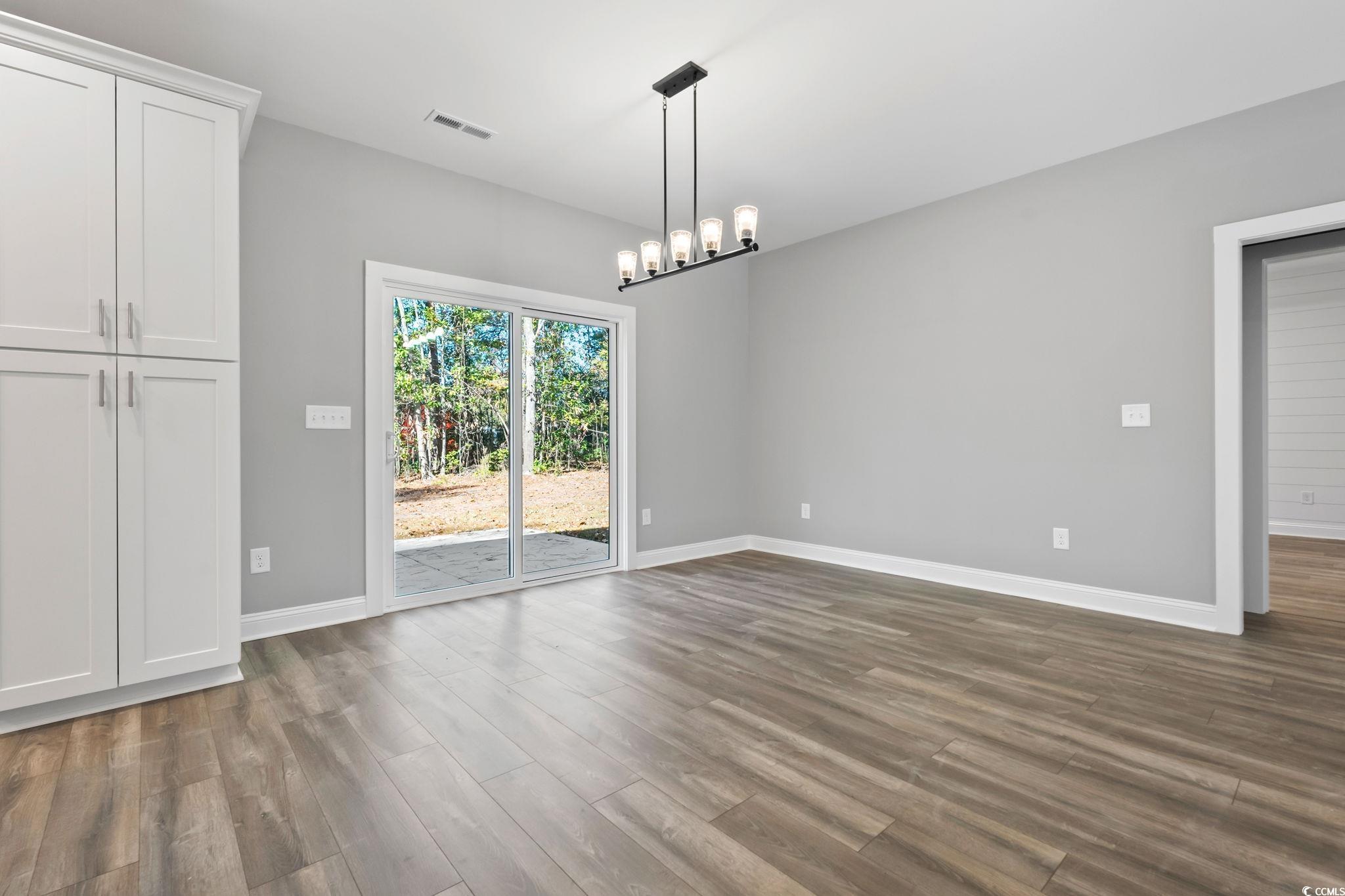 2122 Highway 9 Business Loris, SC 29569 - Photo 15 of 32 Unfurnished dining area featuring dark wood-type flooring and a chandelier