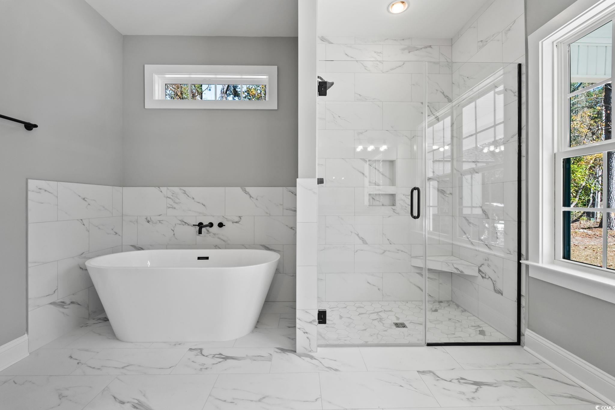 2122 Highway 9 Business Loris, SC 29569 - Photo 23 of 32 Bathroom with healthy amount of natural light, a freestanding tub, marble look tiles, and a marble finish shower