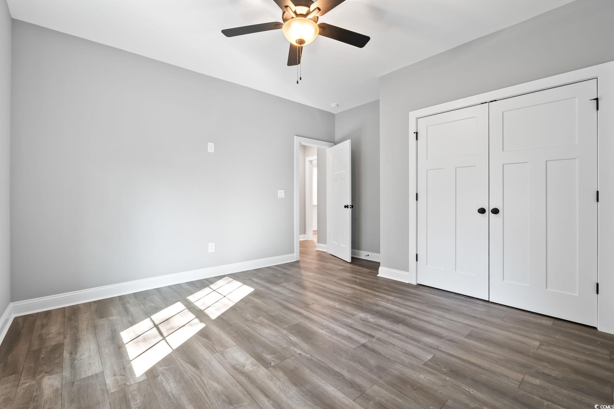 2122 Highway 9 Business Loris, SC 29569 - Photo 25 of 32 Unfurnished bedroom with wood finished floors, a ceiling fan, and a closet