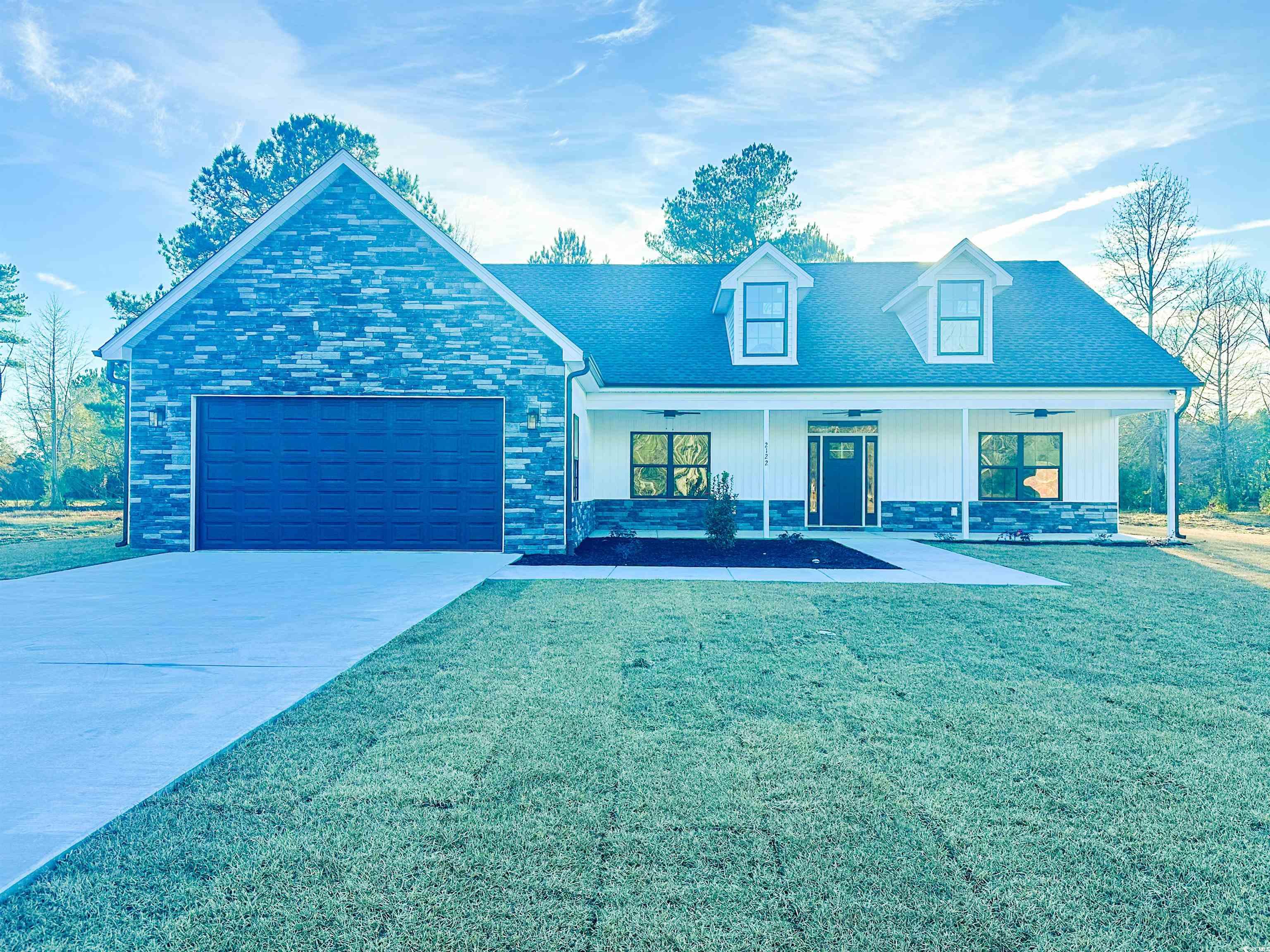 2122 Highway 9 Business Loris, SC 29569 - Photo 3 of 32 View of front of property featuring concrete driveway, a porch, a front yard, stone siding, and an attached garage