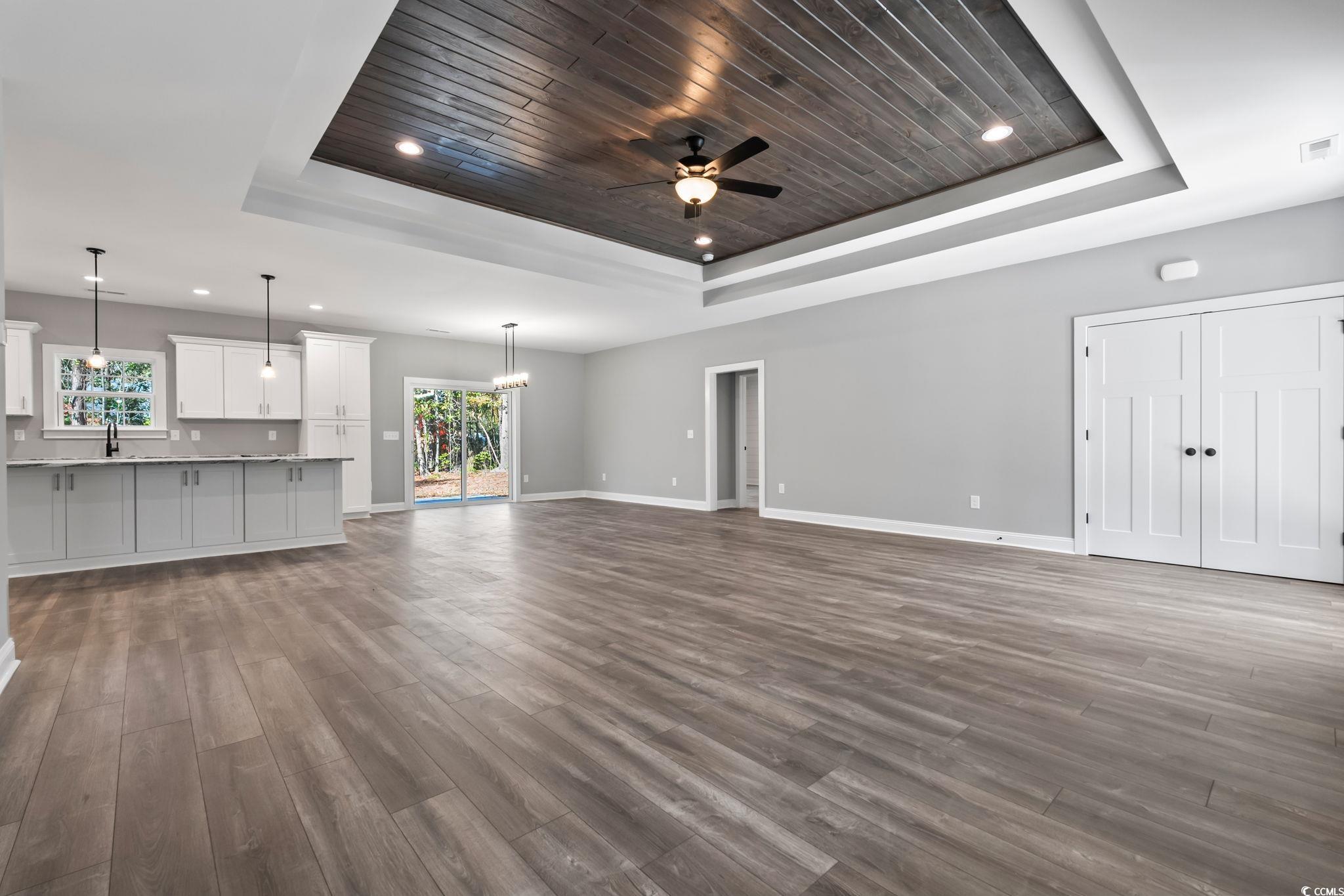 2122 Highway 9 Business Loris, SC 29569 - Photo 6 of 32 Unfurnished living room with a tray ceiling, dark wood-style floors, recessed lighting, a chandelier, and wooden ceiling