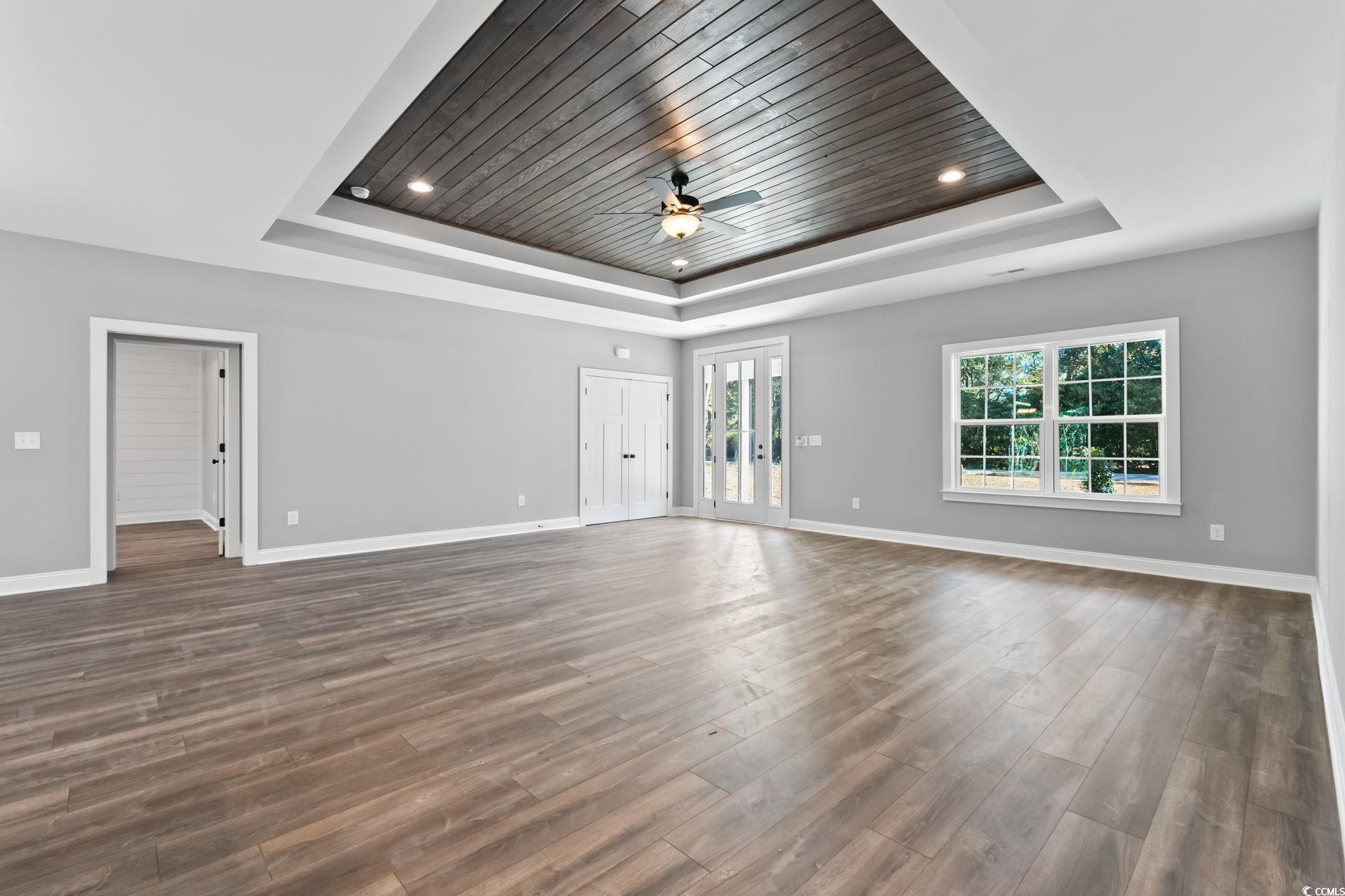 2122 Highway 9 Business Loris, SC 29569 - Photo 8 of 32 Unfurnished living room featuring dark wood-style flooring, a ceiling fan, a tray ceiling, and recessed lighting