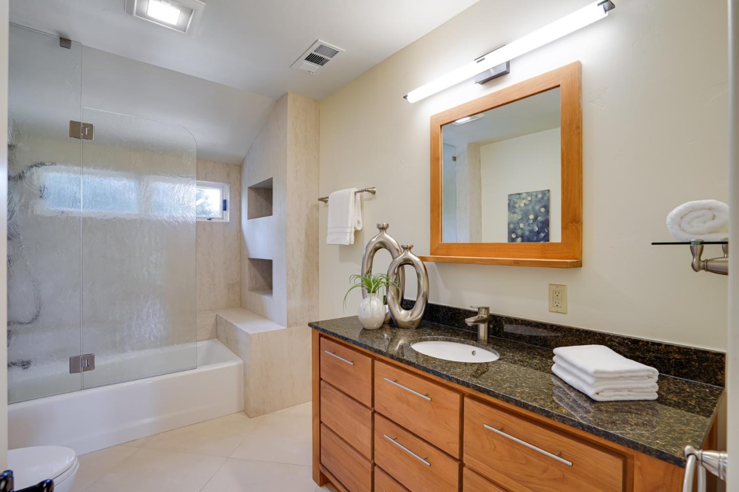 472 Edgewood Road San Mateo, CA 94402 - Photo 41 of 77 a bathroom with a granite countertop sink mirror and a bath tub