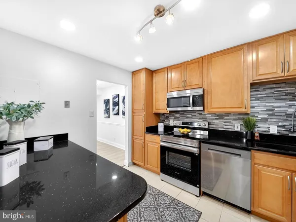 a kitchen with granite countertop stainless steel appliances and wooden cabinets