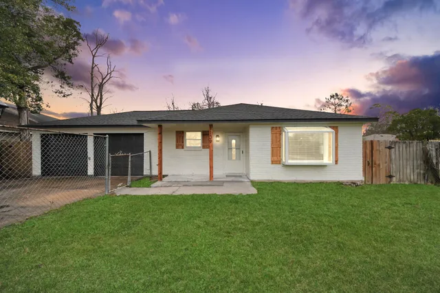 a front view of a house with a garden and yard