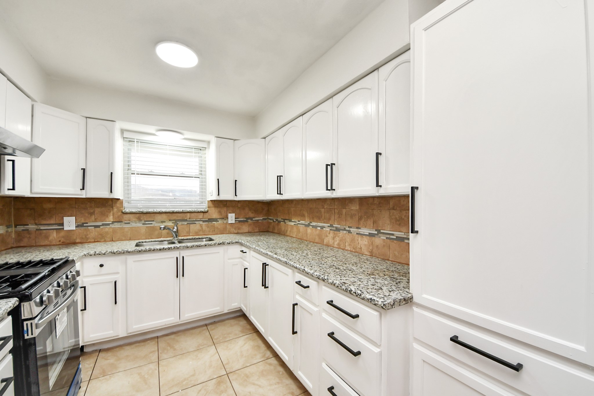 1139 Hartwick Road Houston, TX 77037 - Photo 20 of 38 a kitchen with granite countertop white cabinets and white appliances