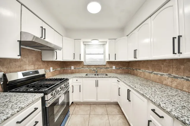 a kitchen with a sink stove top oven and cabinets