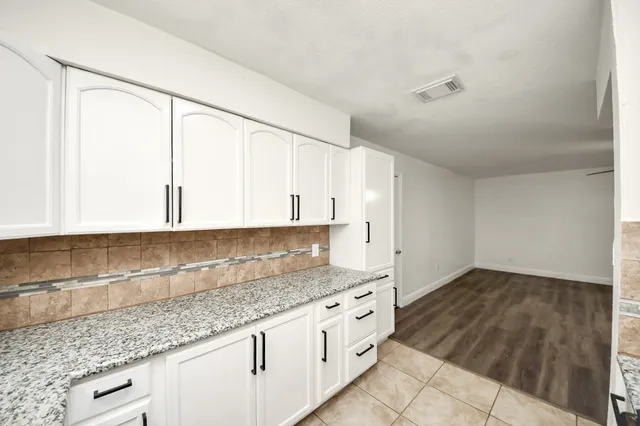 a kitchen with granite countertop a sink and cabinets