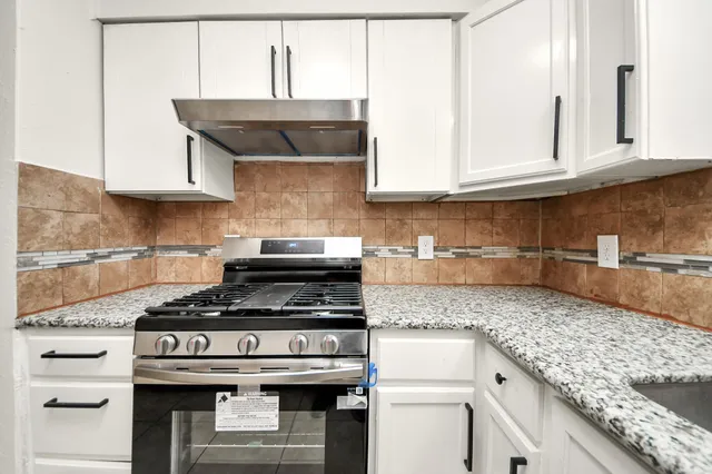a kitchen with stainless steel appliances granite countertop a sink and a stove
