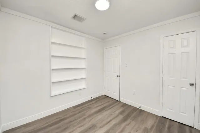 a view of a room with wooden floor and white walls